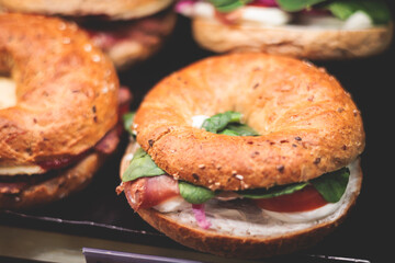Beautifully decorated catering banquet table on event with different food snacks and appetizers setting with bagel and sandwiches, triange, baguette club submarine sandwich, on a wooden plate