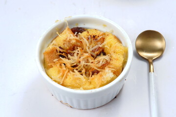 Homemade bread butter pudding with raisins and grated cheese as topping	