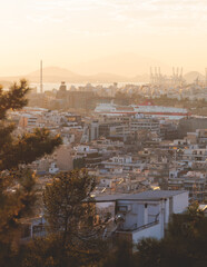 Obraz premium Piraeus city, Attica, beautiful panoramic view of Piraeus, Greece, with harbour and port, mountains and scenery beyond the city, seen from Prophet Helias Hill on Kastela Hill, sunset summer view