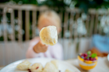 little girl eating dumpling in cafe