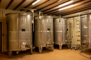 Stages of wine production from fermentation to bottling, visit to wine cellars in Burgundy, France. Steel vats for fermentation.
