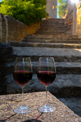 Glass of red dry wine and ruins of medieval castle of Châteauneuf-du-Pape ancient wine making village in France