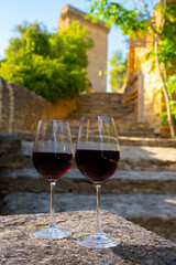 Glass of red dry wine and ruins of medieval castle of Châteauneuf-du-Pape ancient wine making village in France