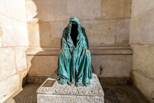 The “Pietá” by Anna Chromy, a statue of a hollow figure wearing a cloak next to the Salzburg Cathedral in the historic old town center of Salzburg, Austria.