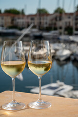 Drinking of cold white wine  with view on yacht harbour of Port Grimaud, summer vacation on French Riviera, France