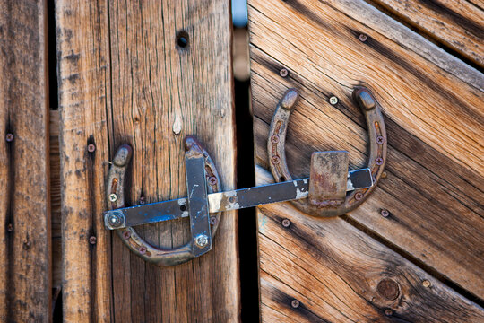 Western barn door with homemade latch made out from old horseshoes.