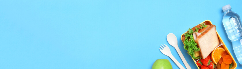 School meal. Flat lay composition with tasty food, water and cutlery on light blue background, space for text. Banner design