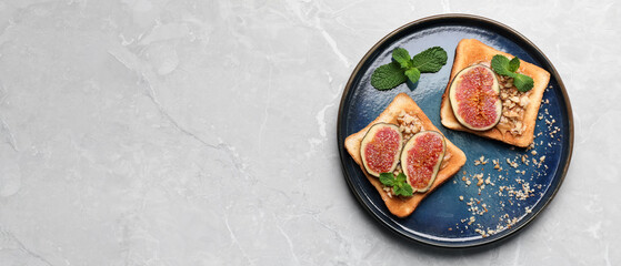 Tasty toasts with fig pieces, peanut butter and walnuts on light grey marble table, top view with space for text. Banner design