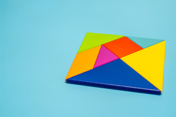 Wood tangram on blue background
