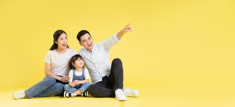 Image Of Asian Family Sitting Together Happy And Isolated On Yellow Background