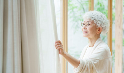 窓の外を眺めるシニア女性