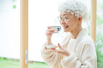 リビングでお茶を飲むシニア女性