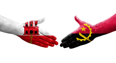 Handshake between Angola and Gibraltar flags painted on hands, isolated transparent image.
