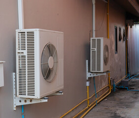 The air conditioner compressor is installed on the outer wall of the building.