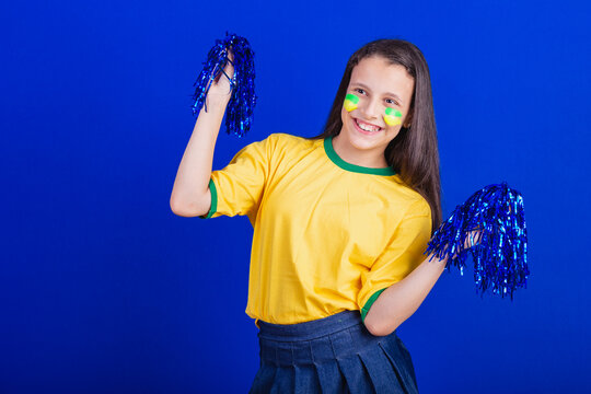 young girl, soccer fan from Brazil. holding cheerleader pompom