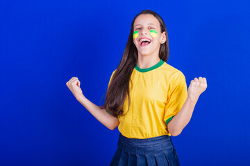 young girl, soccer fan from Brazil. partying, celebrating.