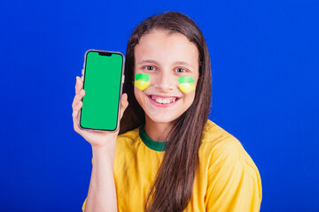 young girl, soccer fan from Brazil. holding cellphone, screen for advertisement, promotion....