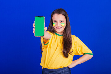 young girl, soccer fan from Brazil. holding cellphone, screen for advertisement, promotion....