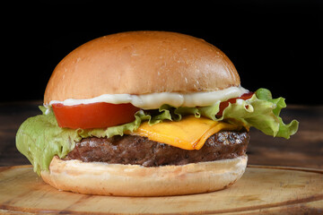 tasty hamburger sandwich with tomato onion salad and bread isolated on black background