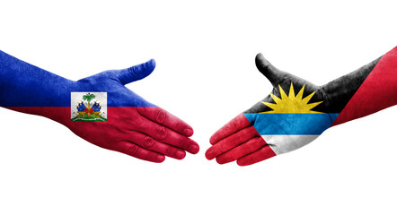 Handshake between Antigua and Barbuda and Haiti flags painted on hands, isolated transparent image.