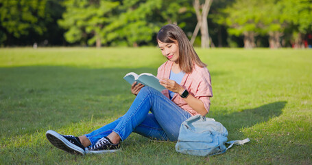 asian woman reading on lawn