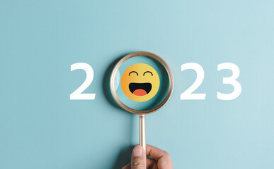 Smiley face on 2023 year concept. Magnifier focus to yellow emoticon face. happy to next year from...
