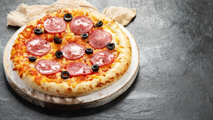 Freshly baked pepperoni pizza on dark background.