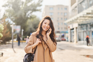 Lifestyle portrait happy Asian kazakh woman talking on mobile phone and laughing - 537693742