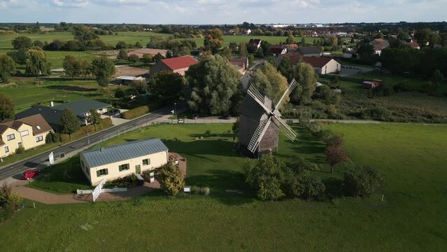 Attraction of the village. Fantastic aerial view flight big panorama orbit drone of a old Wooden Trestle windmill in brandenburg Germany at summer golden hour 2022. 4k marnitz Cinematic