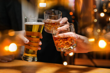food and drink male friends are happy drinking beer and clinking glasses at a bar or pub.