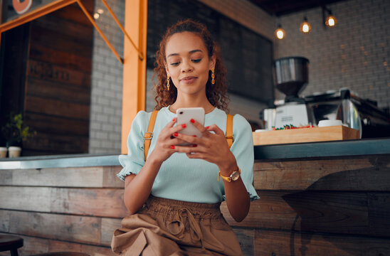 Phone, social media and coffee shop with a woman typing a text message while sitting in a cafe to relax. Internet, mobile and communication with a young female customer in a restaurant texting