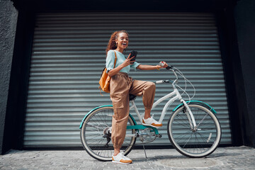Bicycle, woman and phone in city feeling excited and happy about message while outdoor in summer with trendy look. Eco friendly transportation for carbon footprint female on a bike using 5g network - Powered by Adobe