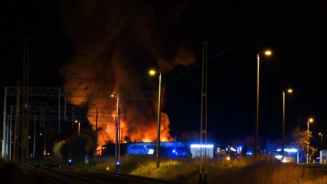 firery exposion at night with firefighters working