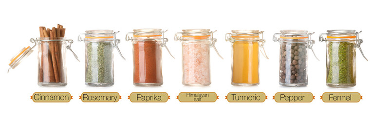 Set of aromatic spices in jars on white background