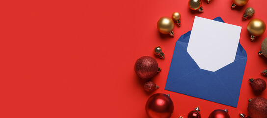 Envelope with blank card and Christmas balls on red background with space for text