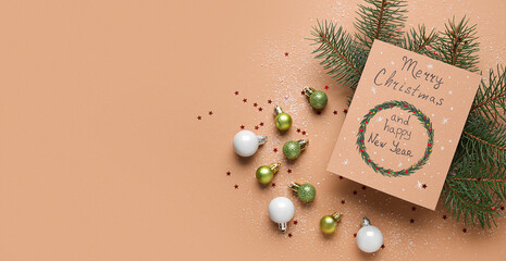 Fototapeta na wymiar Greeting card, Christmas balls and fir branches on beige background with space for text