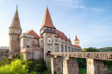 Fototapeta na wymiar Summer view with Corvin castle with bridge over a small river in a sunny day in Romania