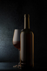 Fototapeta na wymiar red wine glasses and bottle on stone background