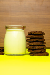 Chocolate chip cookies, milk, yellow background,