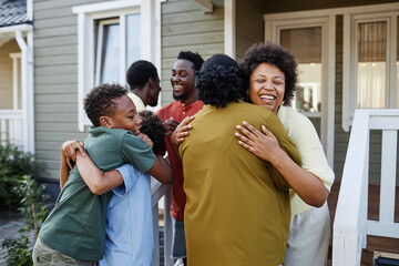 Big African American family embracing outdoors welcoming guests for party - Powered by Adobe