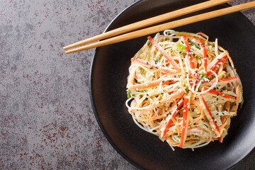 Kani salad is a Japanese style seafood salad made with crab stick closeup in the plate on the...