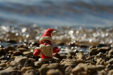 Figure of Santa Claus on the background of the river. Bright sunny summer day. A fairy-tale...