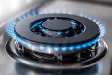 The gas burner burns with the blue flame of a propane butane stove in a home kitchen or hotel restaurant