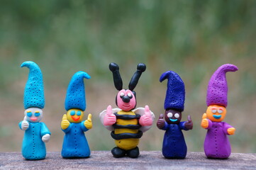 Figures of four colorful dwarfs and bees with thumbs up. Positive mood. Well-being and love....