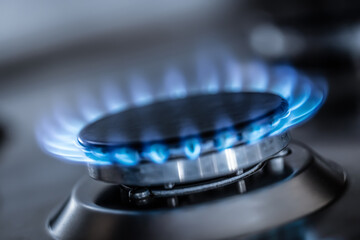 The gas burner burns with the blue flame of a propane butane stove in a home kitchen or hotel restaurant