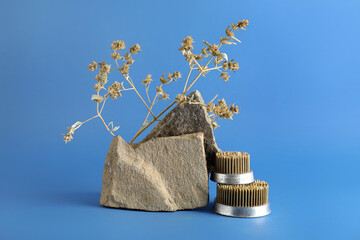 Kenzans for ikebana with rocks and floral branch on blue background