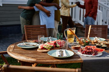 Background image of festive picnic table outdoors with black family celebrating in background, copy space