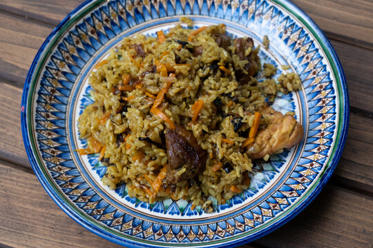 Pilaf on a plate. Uzbek national painting Rishtan. National oriental cuisine.