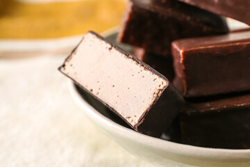 Bowl with tasty bird's milk candies on table, closeup