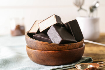 Bowl with tasty bird's milk candies on wooden table, closeup